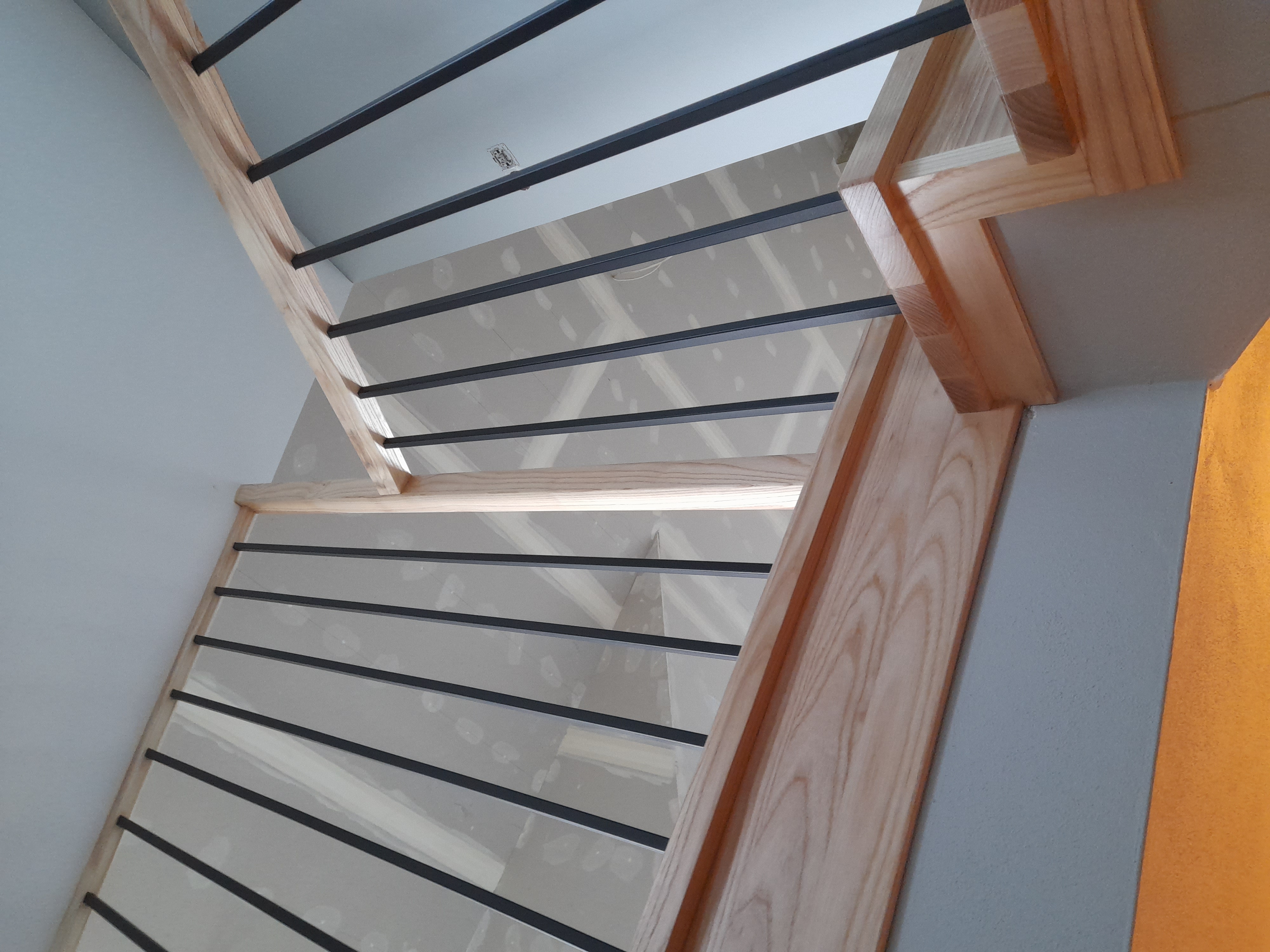 Schody jesionowe z czarną balustradą