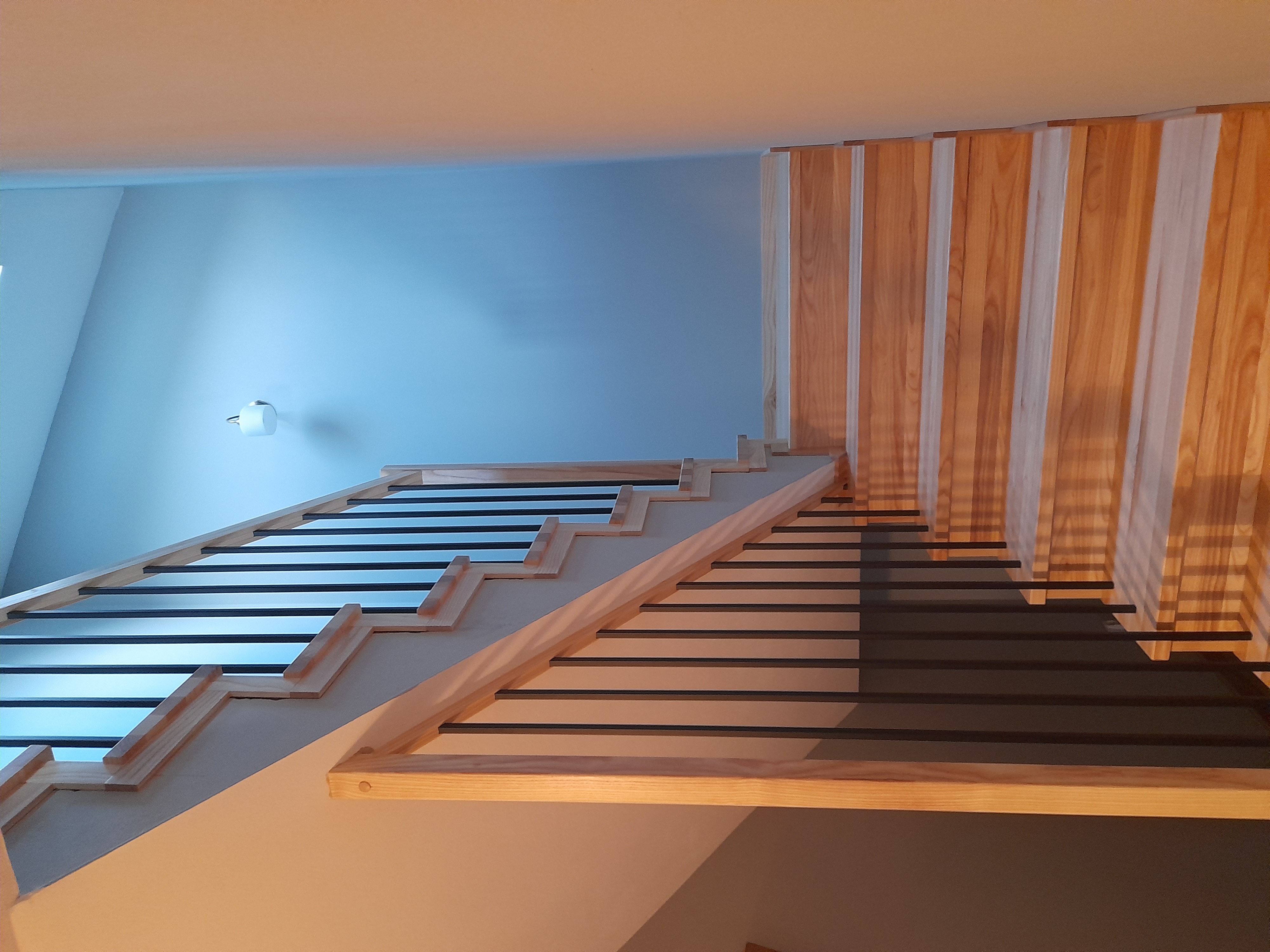 Schody jesionowe z czarną balustradą