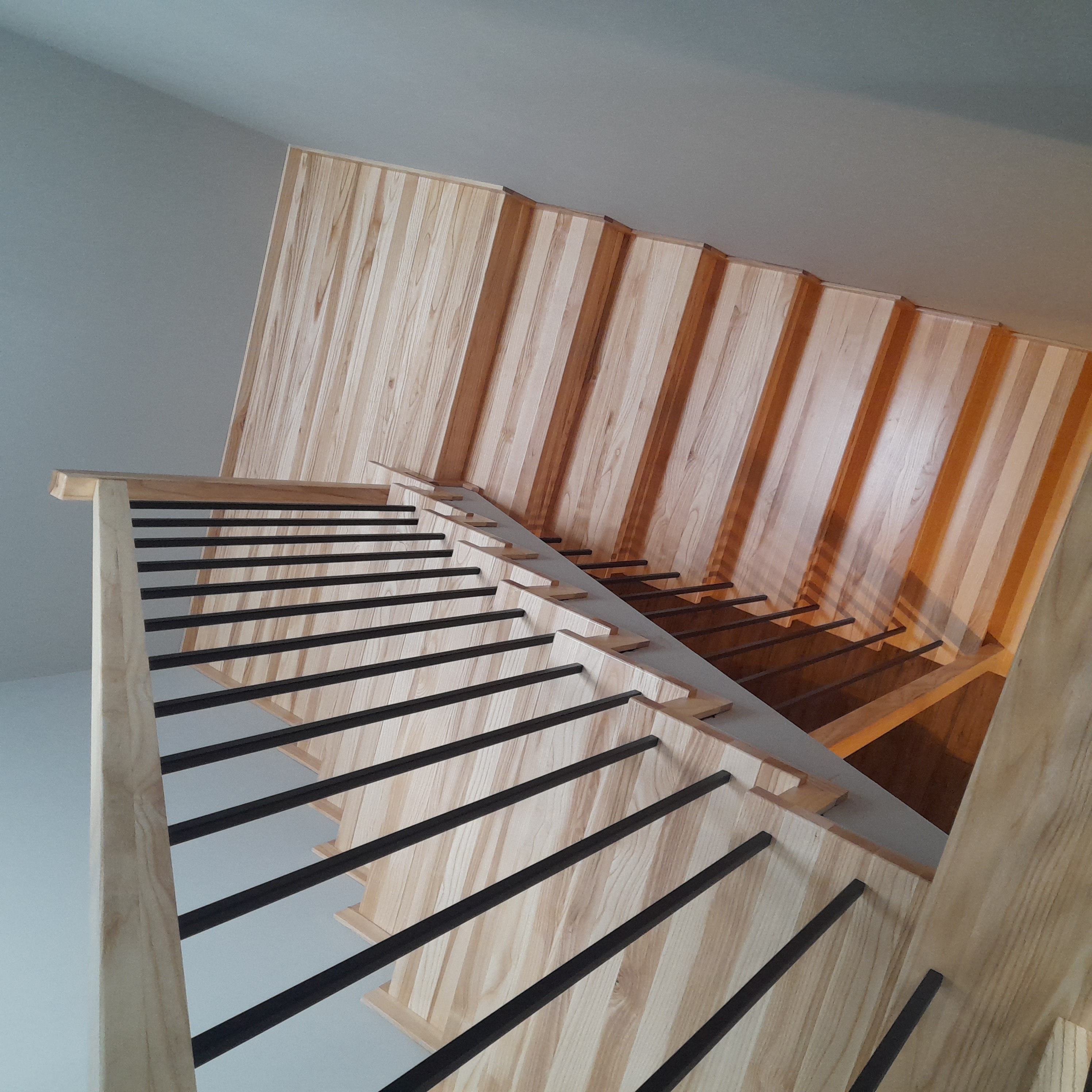 Schody jesionowe z czarną balustradą