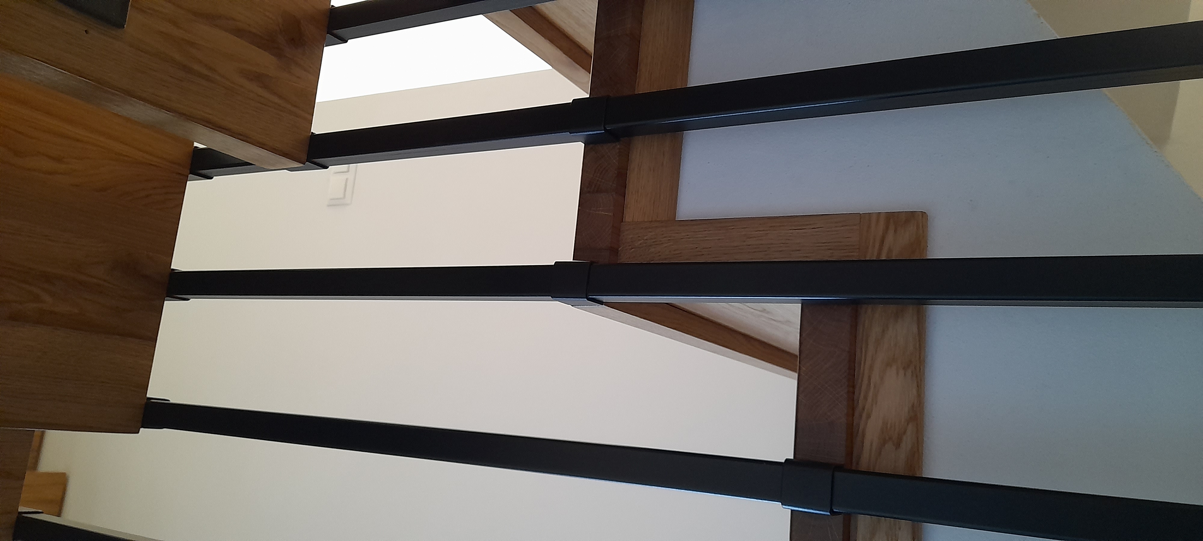 Schody dębowe z czarną balustradą