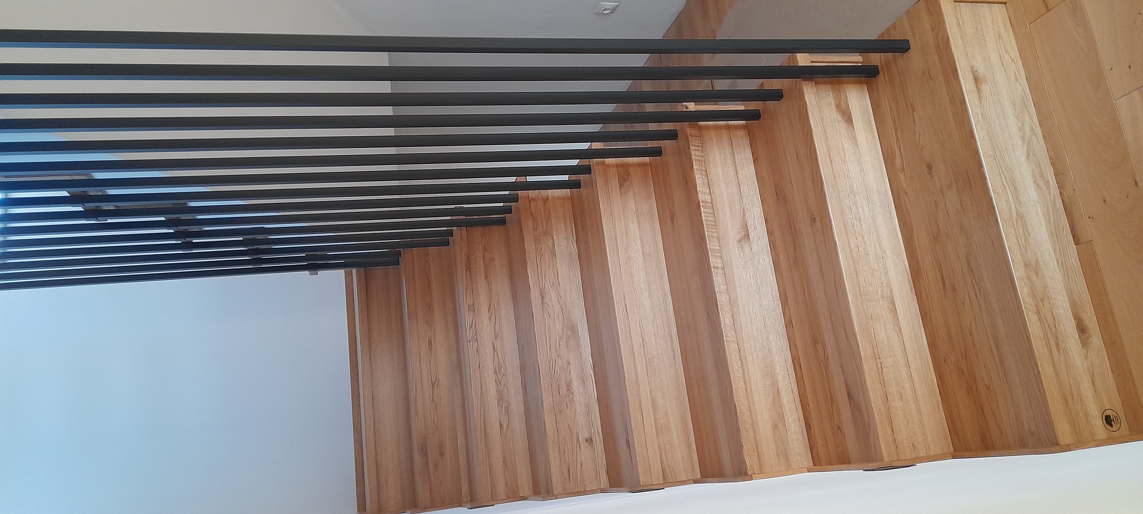 Schody dębowe z czarną balustradą