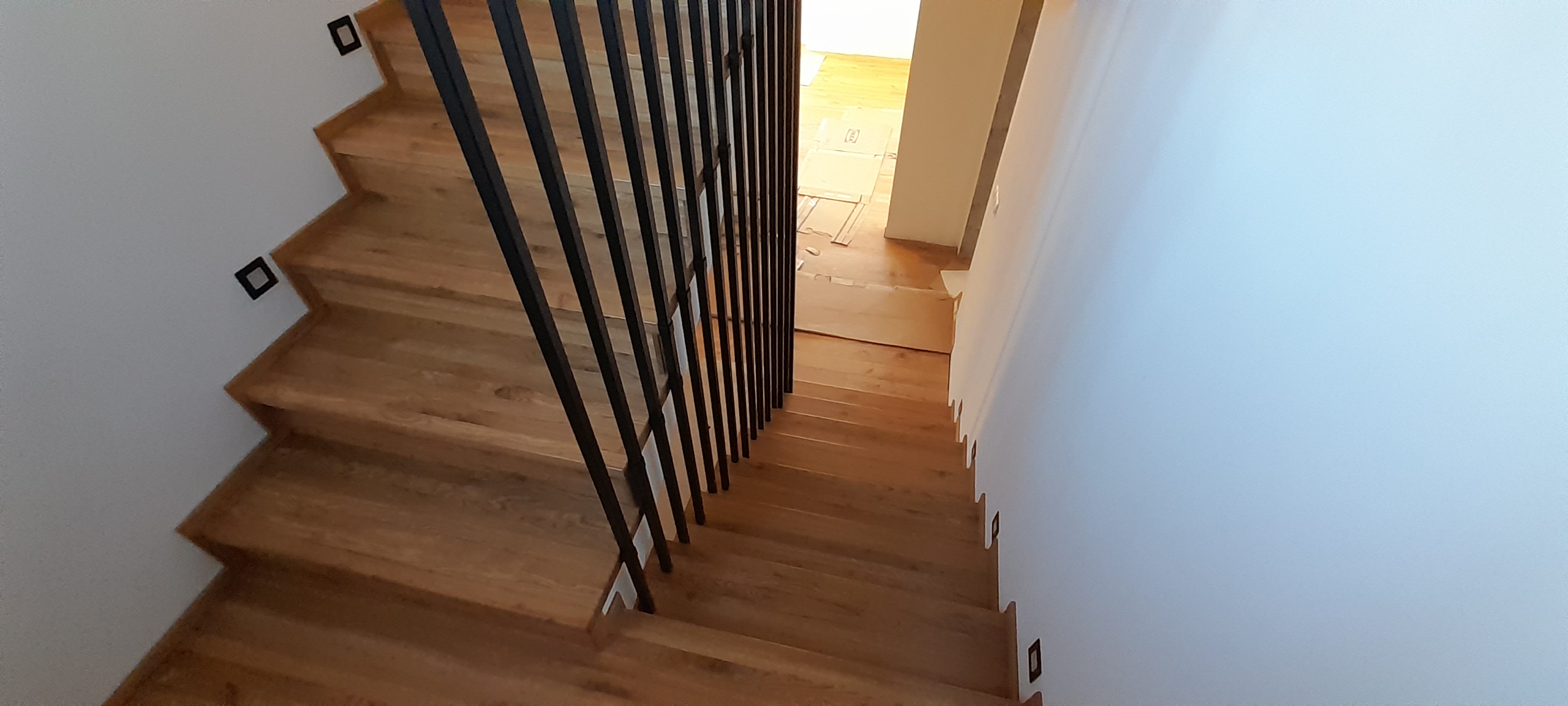 Schody dębowe z czarną balustradą